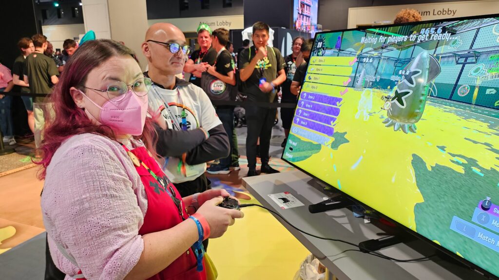 Sam in a mask in front of a TV looking very happy about winning turf war